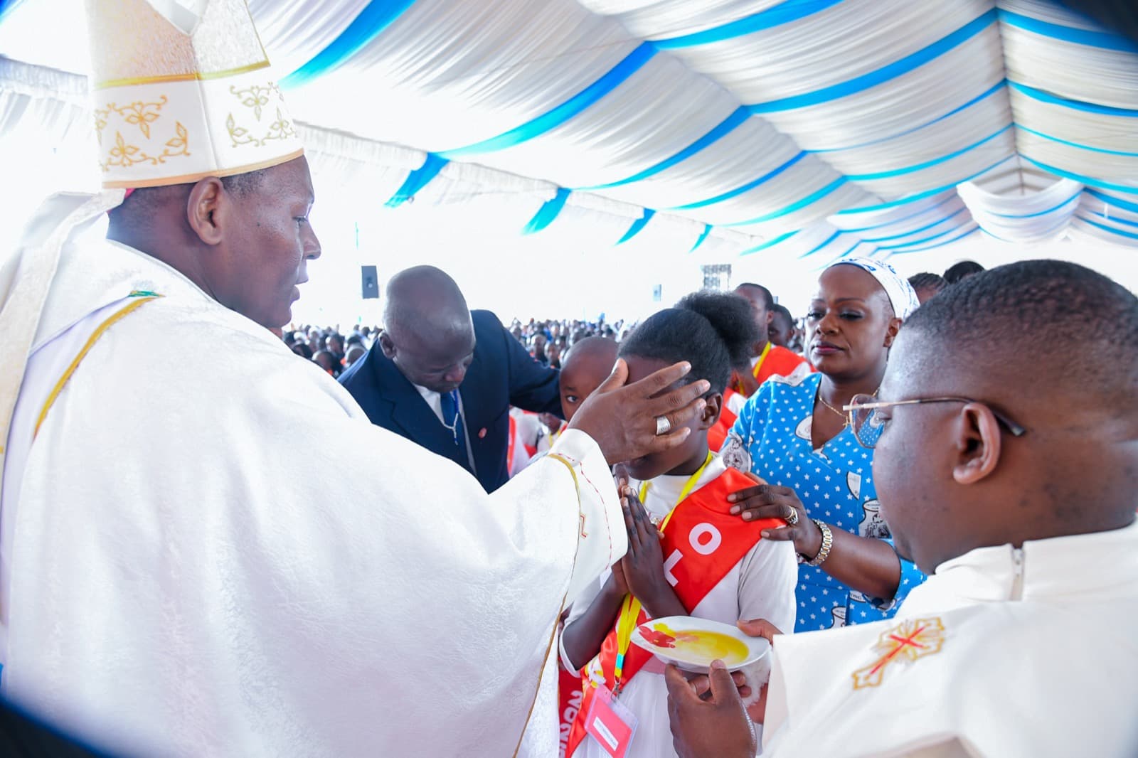 A bishop anoints a child with chrism oil during a Confirmation Mass