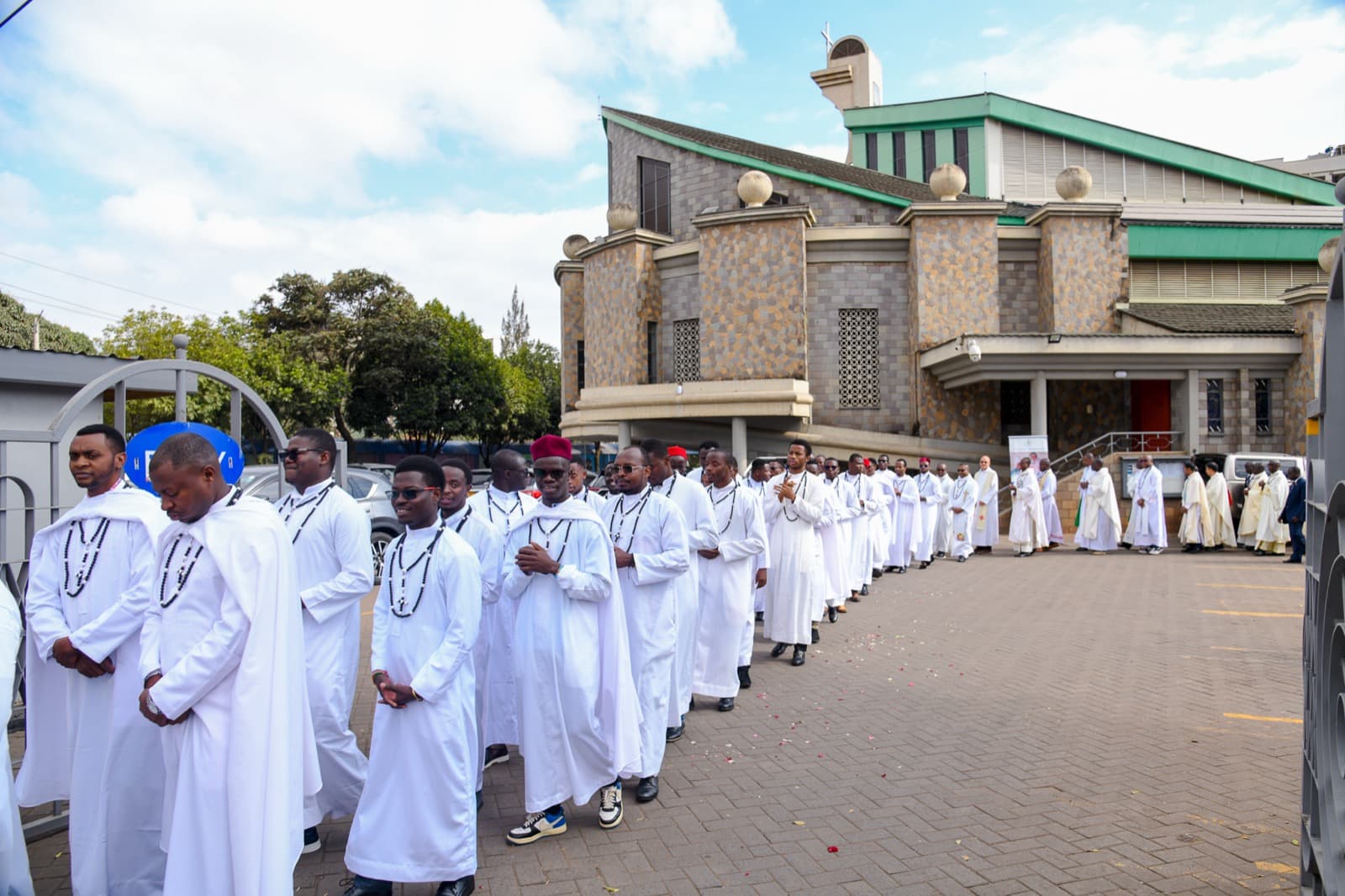 Newly ordained deacons process outside the church behind clergy